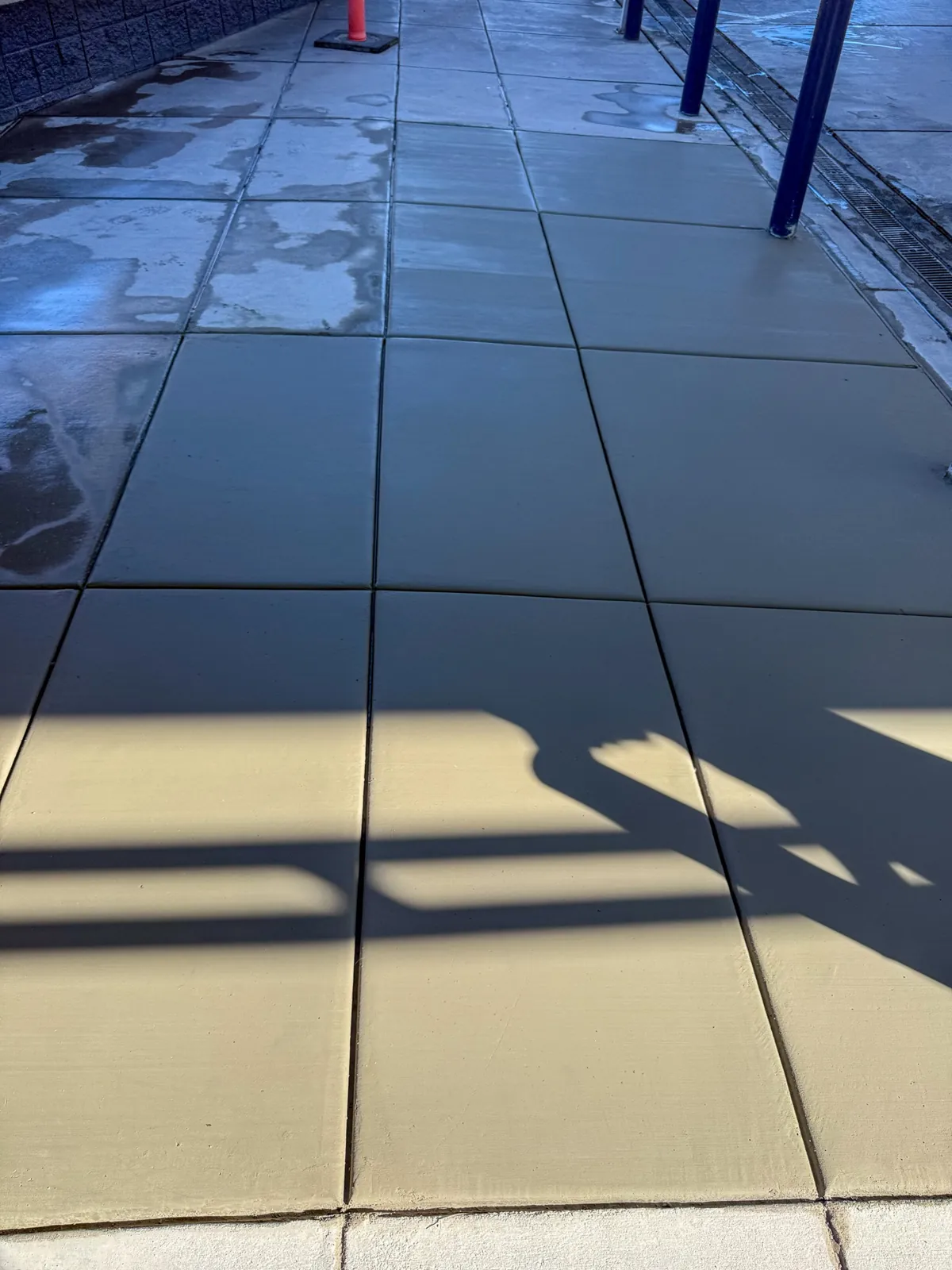 Finished commercial sidewalk with clean control joints and a broom finish